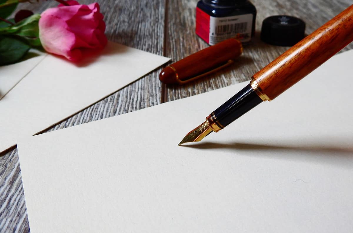 Blue ink on a page beside a fountain pen