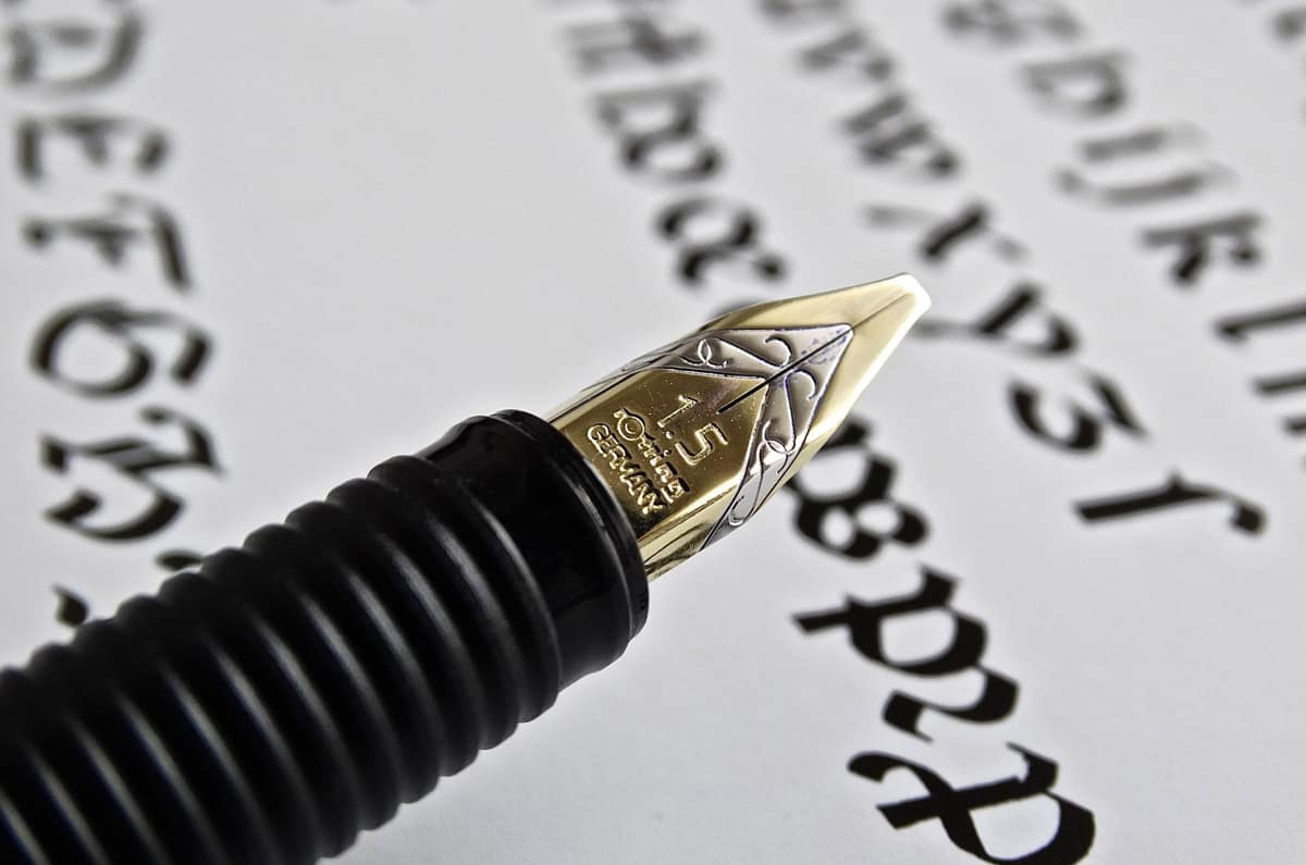 A fine fountain pen nib writing small text on paper