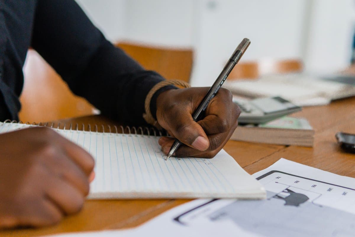 A left-handed writer working in a notebook
