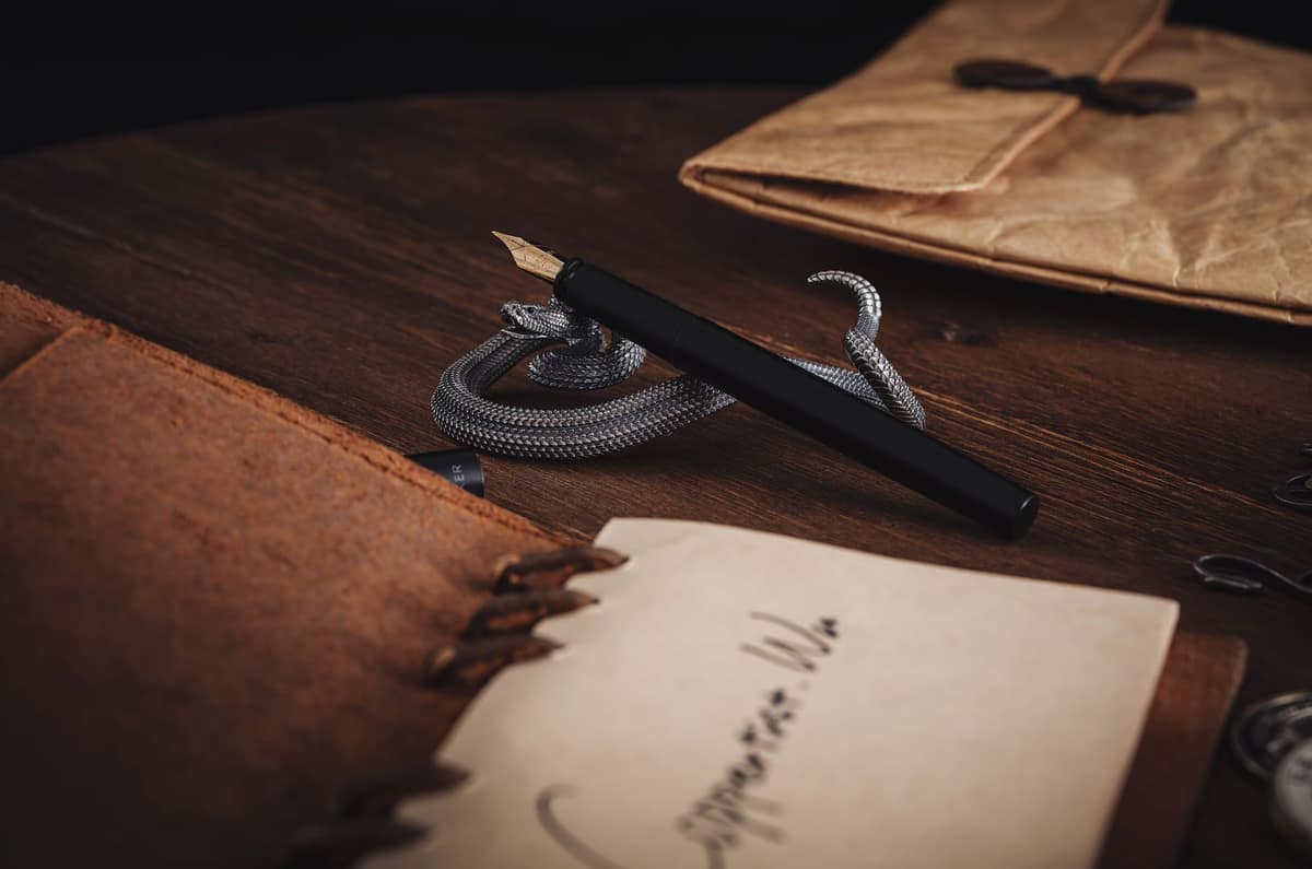 A metal fountain pen resting on a wooden desk