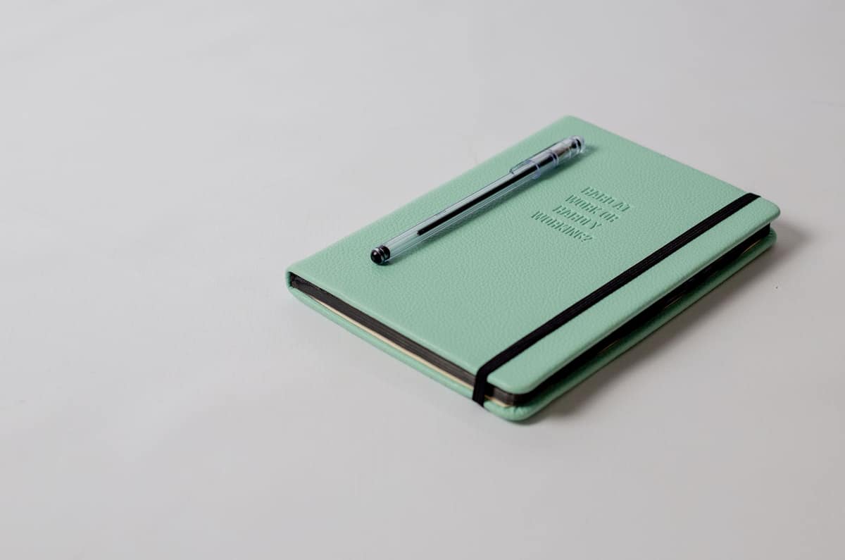 A leather-bound journal and a fountain pen on a wooden surface