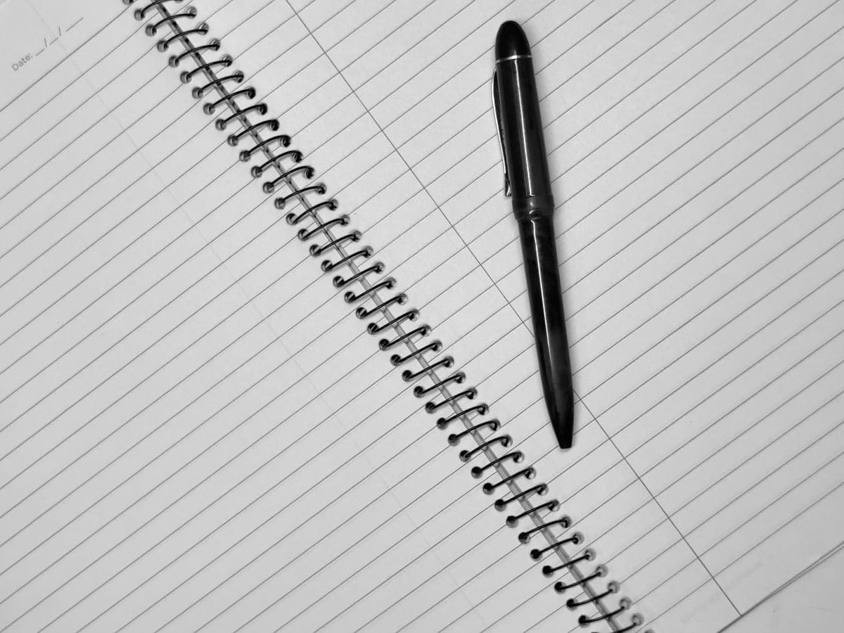 A black fountain pen resting on a notebook page