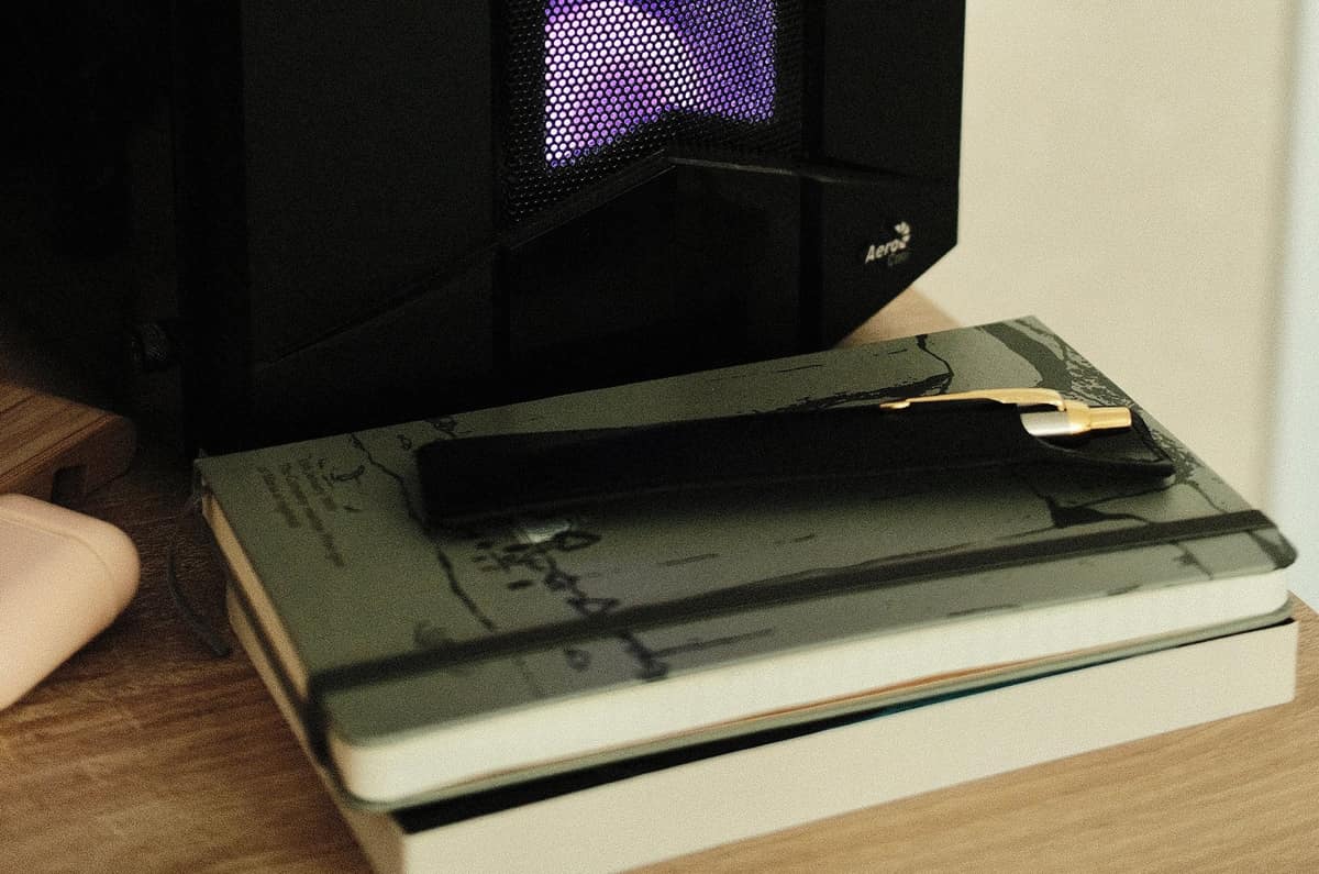 Two notebooks stacked on a wooden desk