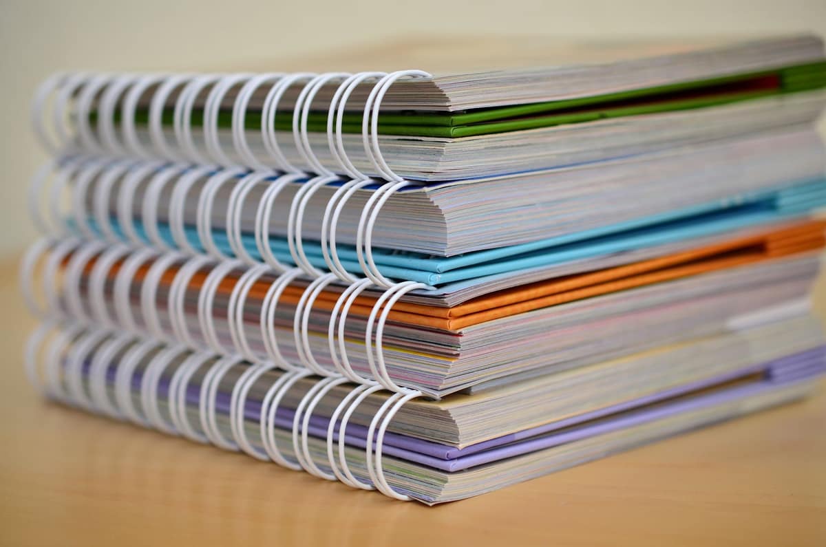 A stack of notebooks from several brands on a desk