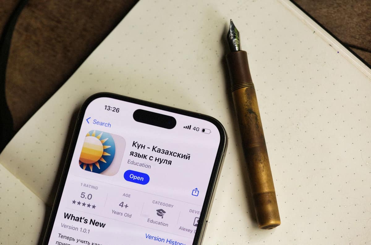 A short fountain pen lying beside a notebook