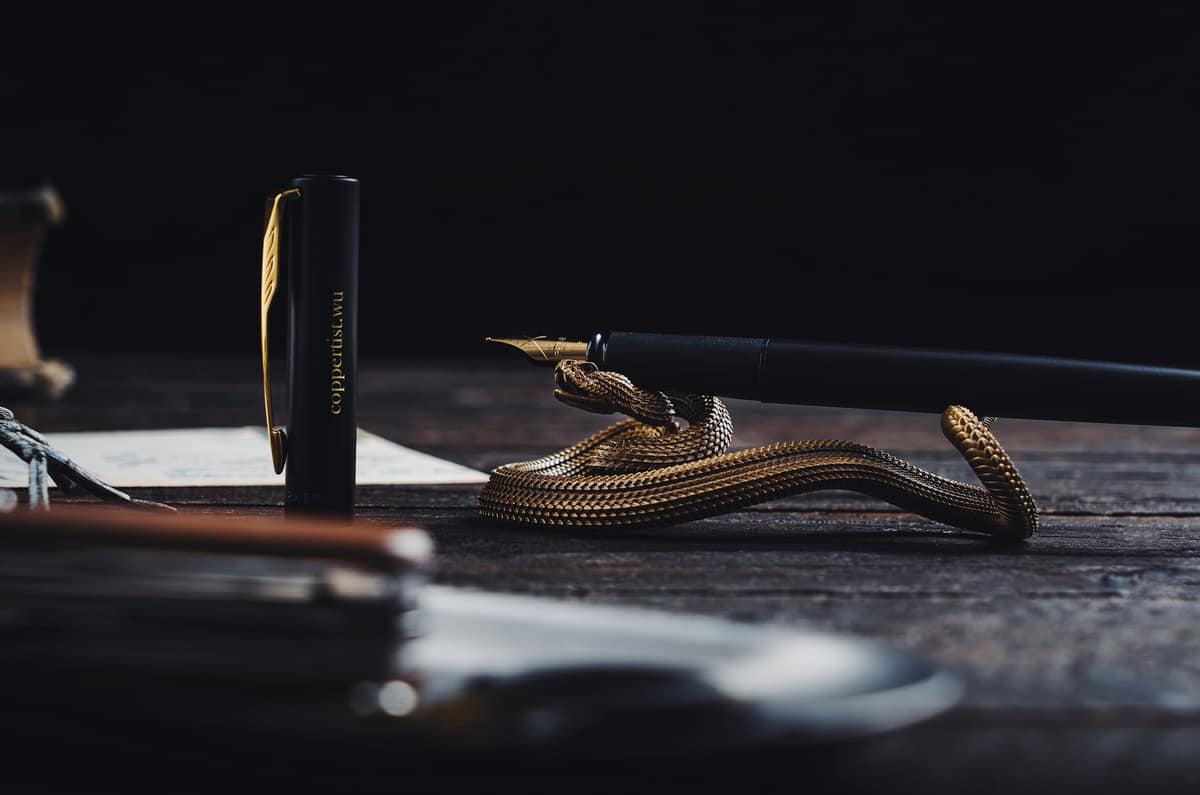 A metal fountain pen cap resting on a desk