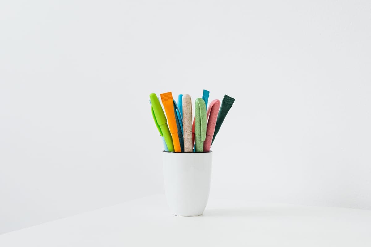 Inexpensive pens standing in a cup on a desk
