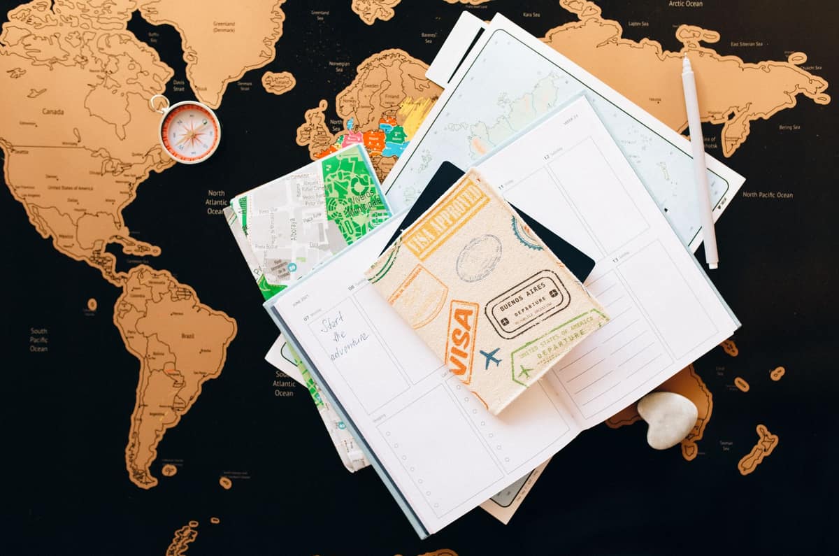 A journal, pen and passport arranged on a table