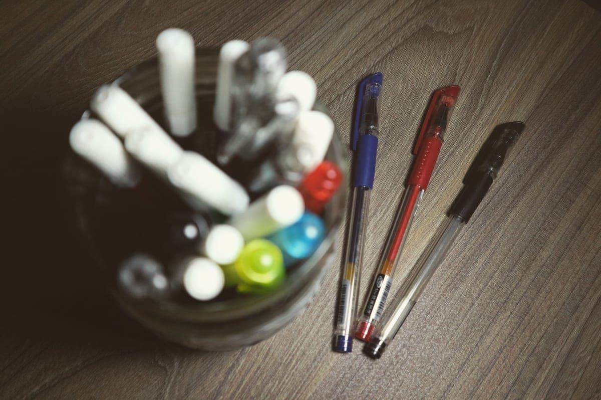 Several pens arranged on a wooden desk